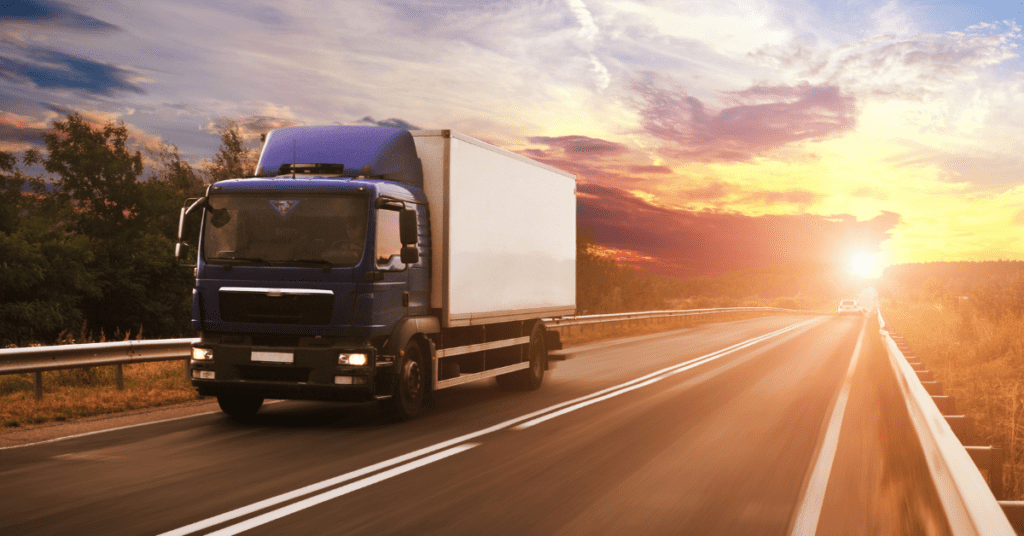 A box truck driving on a highway with cargo