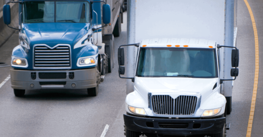 Two freight trucks hauling side-by-side