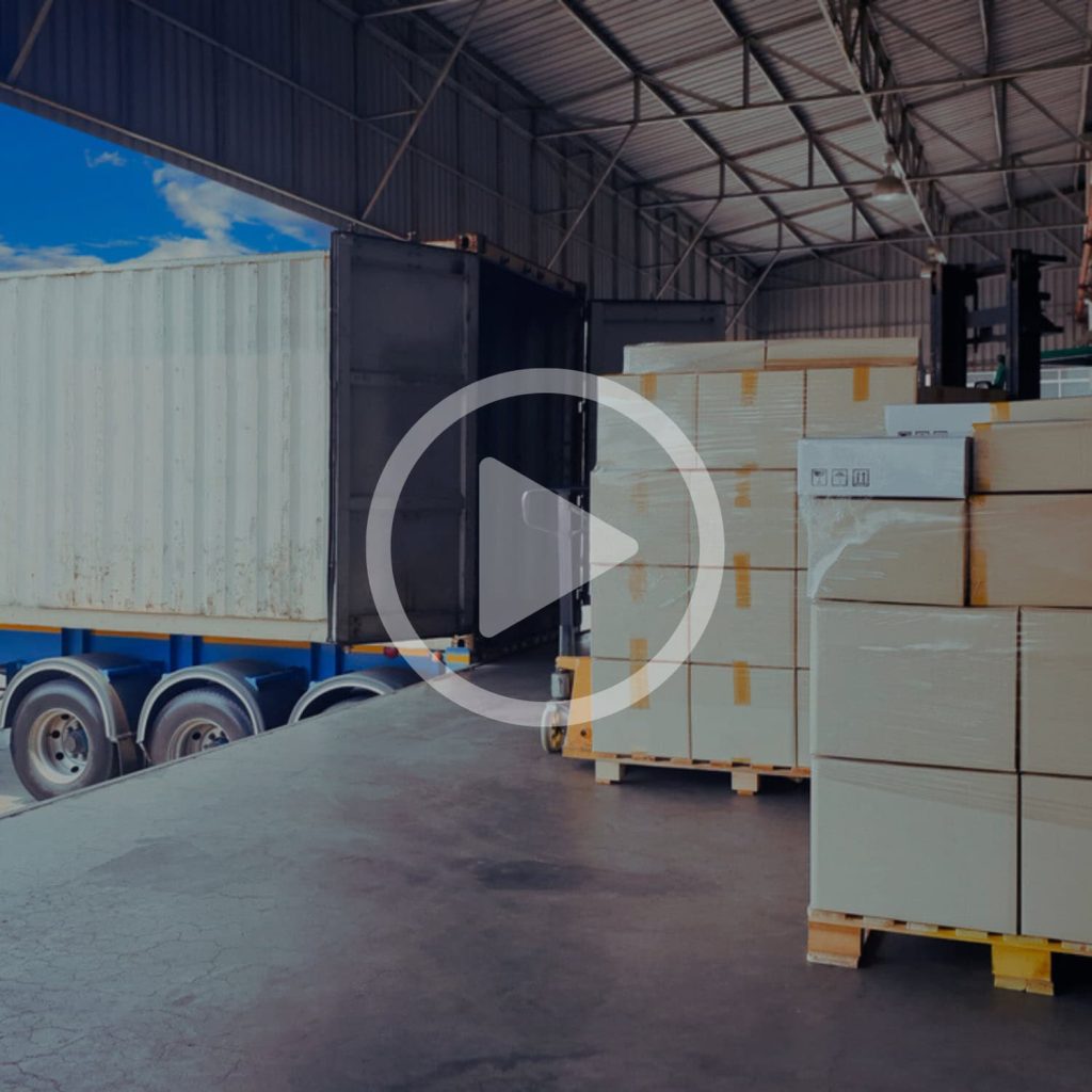 Shipping container with pallets of boxed goods inside a warehouse, showcasing logistics and supply chain solutions.
