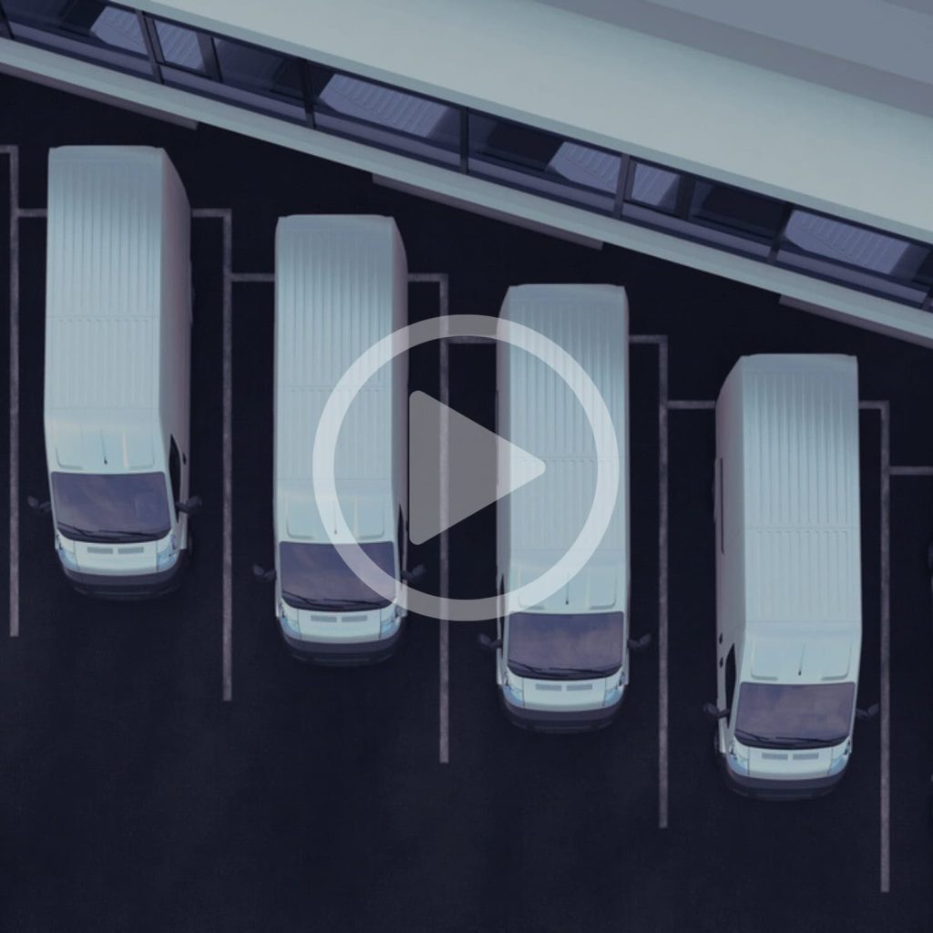 Blue fleet of delivery vans parked in a row in an urban setting.