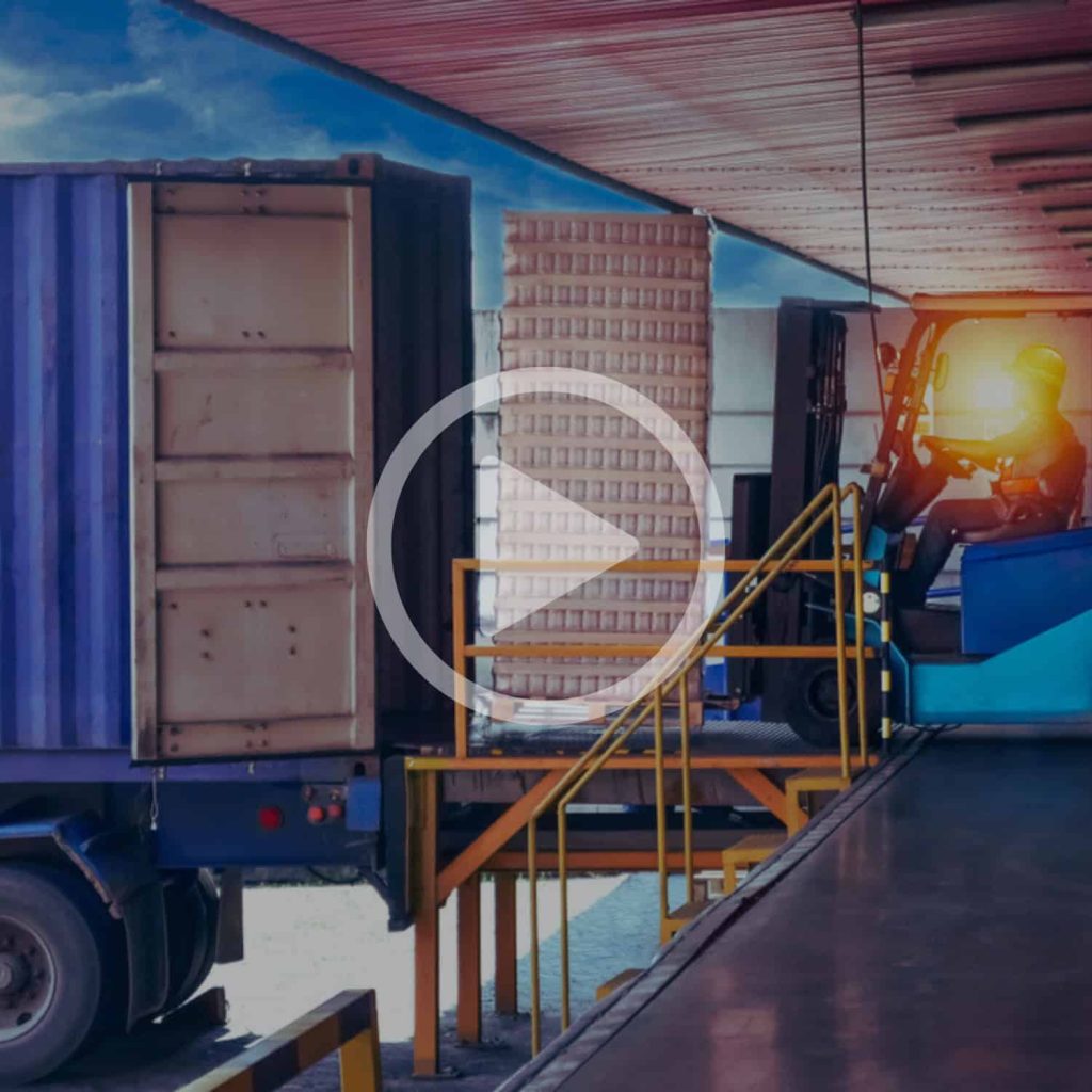 Shipping container being unloaded at a warehouse with a forklift during sunset, showcasing logistics and supply chain solutions.