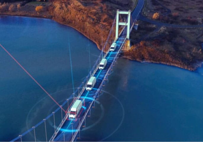 Connected fleet of trucks driving on a high-tech bridge with digital overlay representing IoT and supply chain management for Banyan Technology.