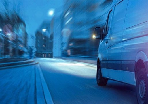 Rapid delivery van in motion through city streets, representing efficient logistics solutions from Banyan Technology.